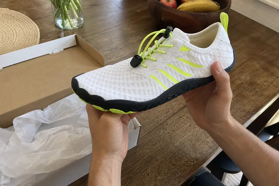 White Grounded-style shoe being inspected after unboxing